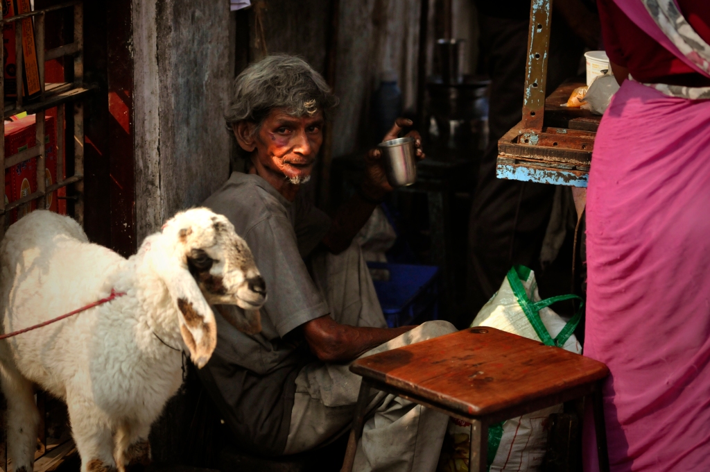 Photo of a man and a goat in Mumbai, India.